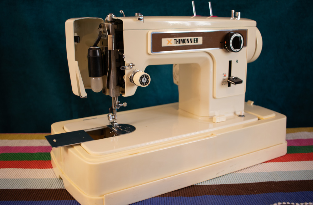 Photo d'une machine à coudre Thimonnier 6100 de biais avec le couvercle de tête ouvert